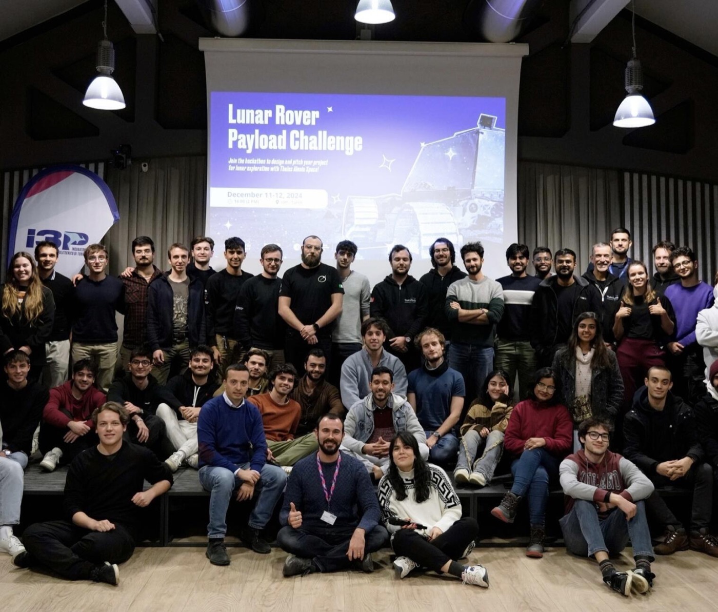 Group photo of the challenge participants in front of the Lunar Rover Payload Challenge slide